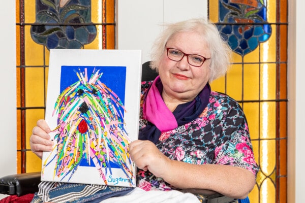 Suzanne is pictured with one of her art pieces. Click to view the full size image.