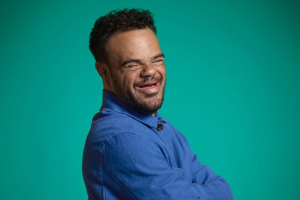A man with a blue shirt and a smile.